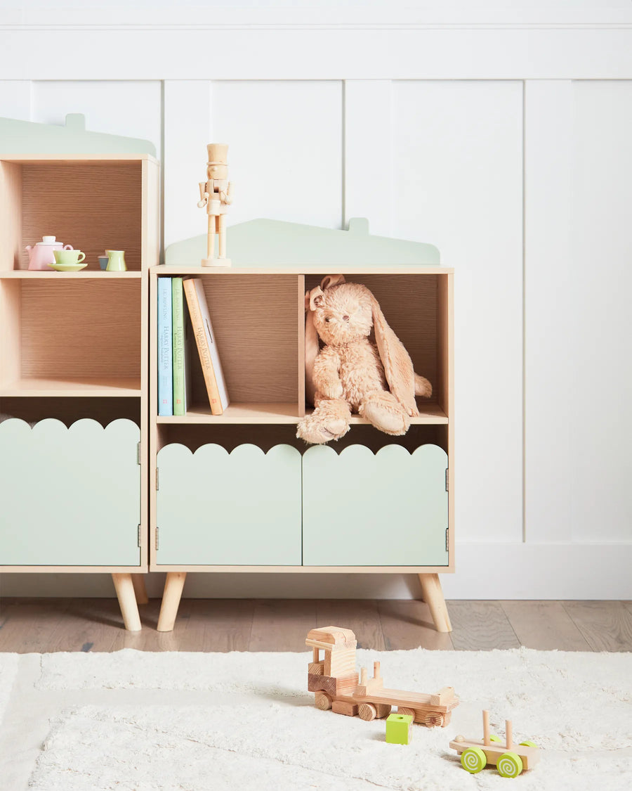 Children's room with a wooden cabinet and toys on a light-colored floor.