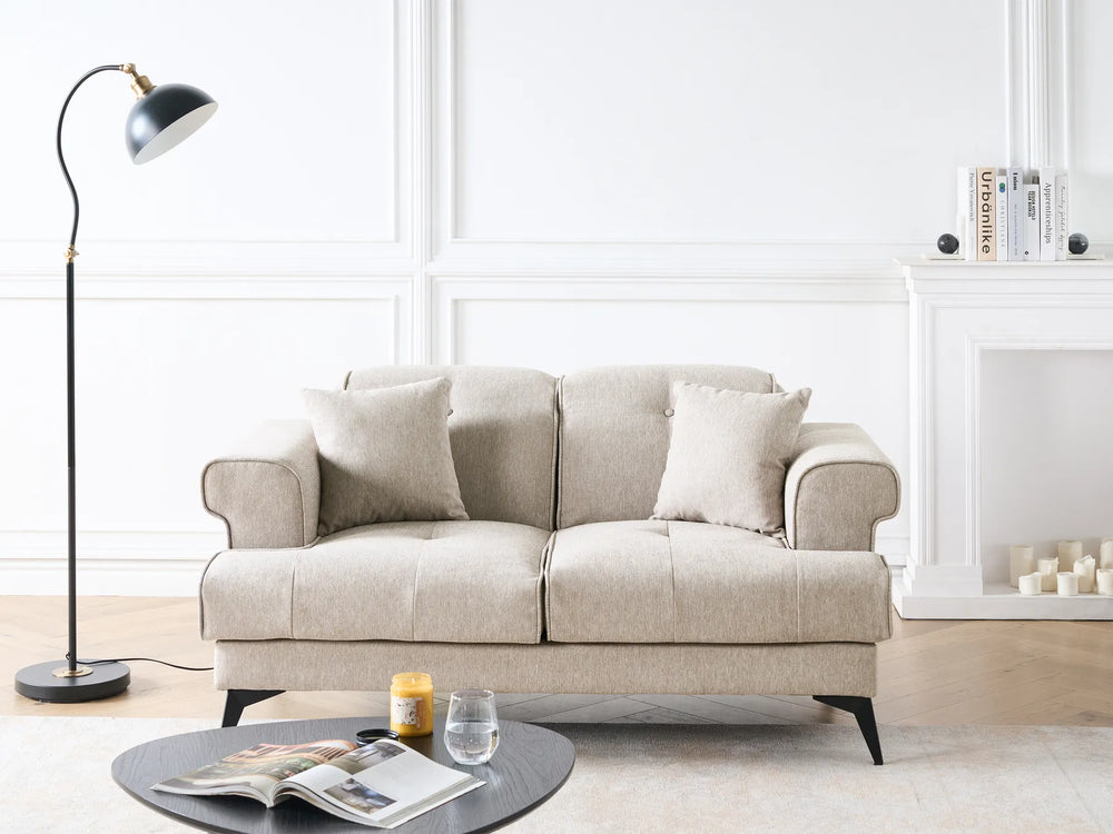 Beige sofa in a living room with a lamp and coffee table.