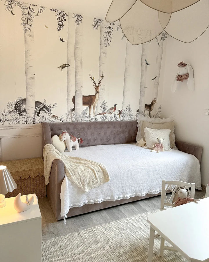 Children's bedroom with forest-themed wallpaper, bed, and toys.