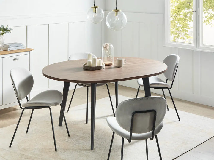 Dining room with a wooden table and gray chairs in a bright room.