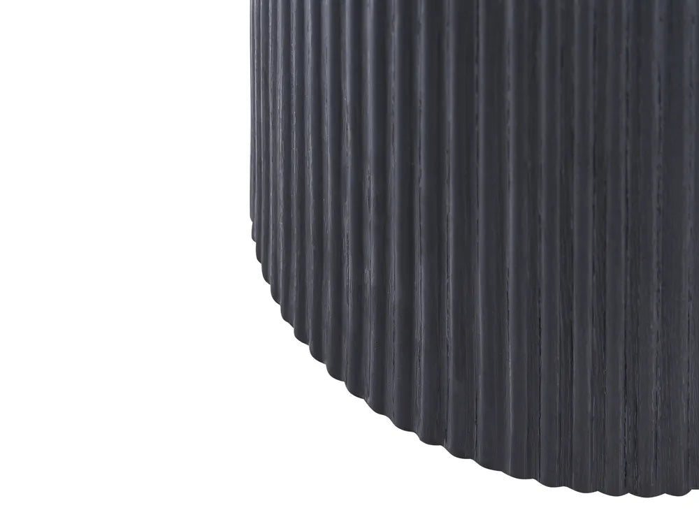 Close-up of a ribbed black cylindrical object on a white background