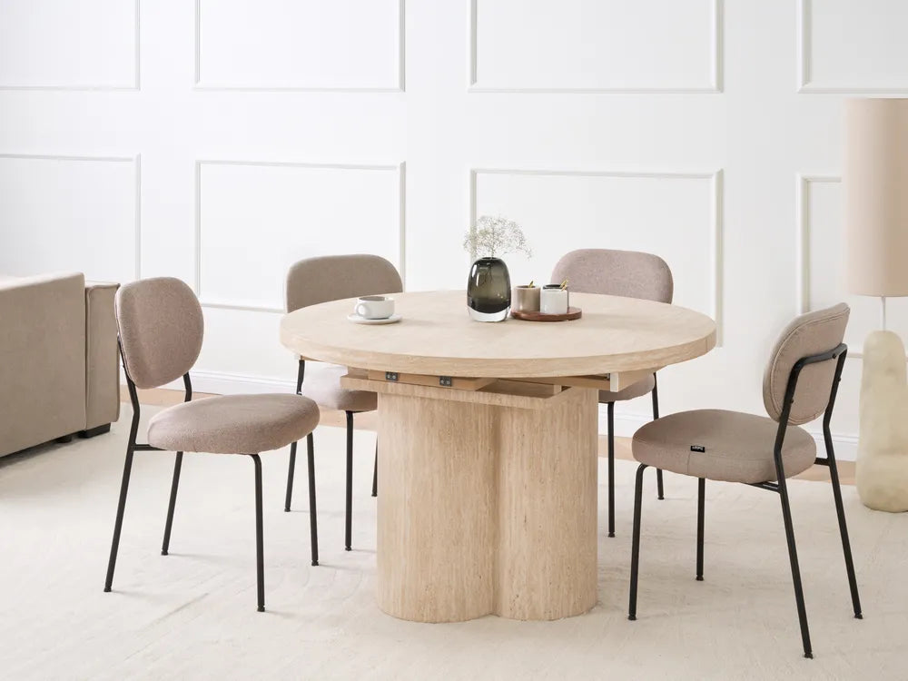 Round wooden dining table with four chairs in a minimalistic room.