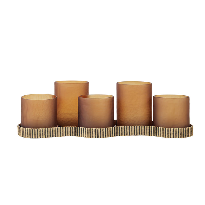 Set of five brown cylindrical candles on a decorative holder with a wavy edge on a white background