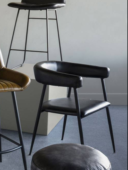 Set of modern bar stools and a pouf in a minimalistic room.