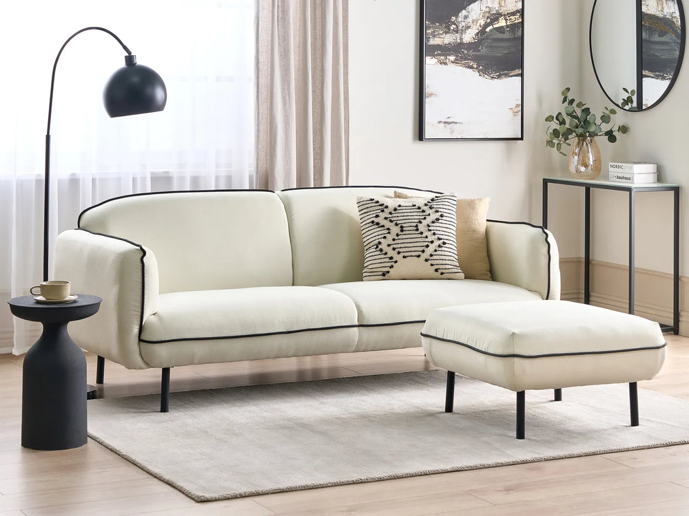 Modern living room with a beige sofa and ottoman, side table, and decorative elements.