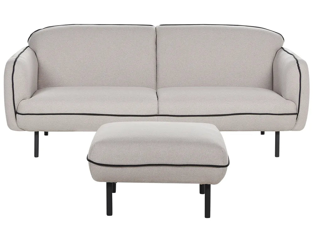 Beige sofa with black piping and matching ottoman on a white background