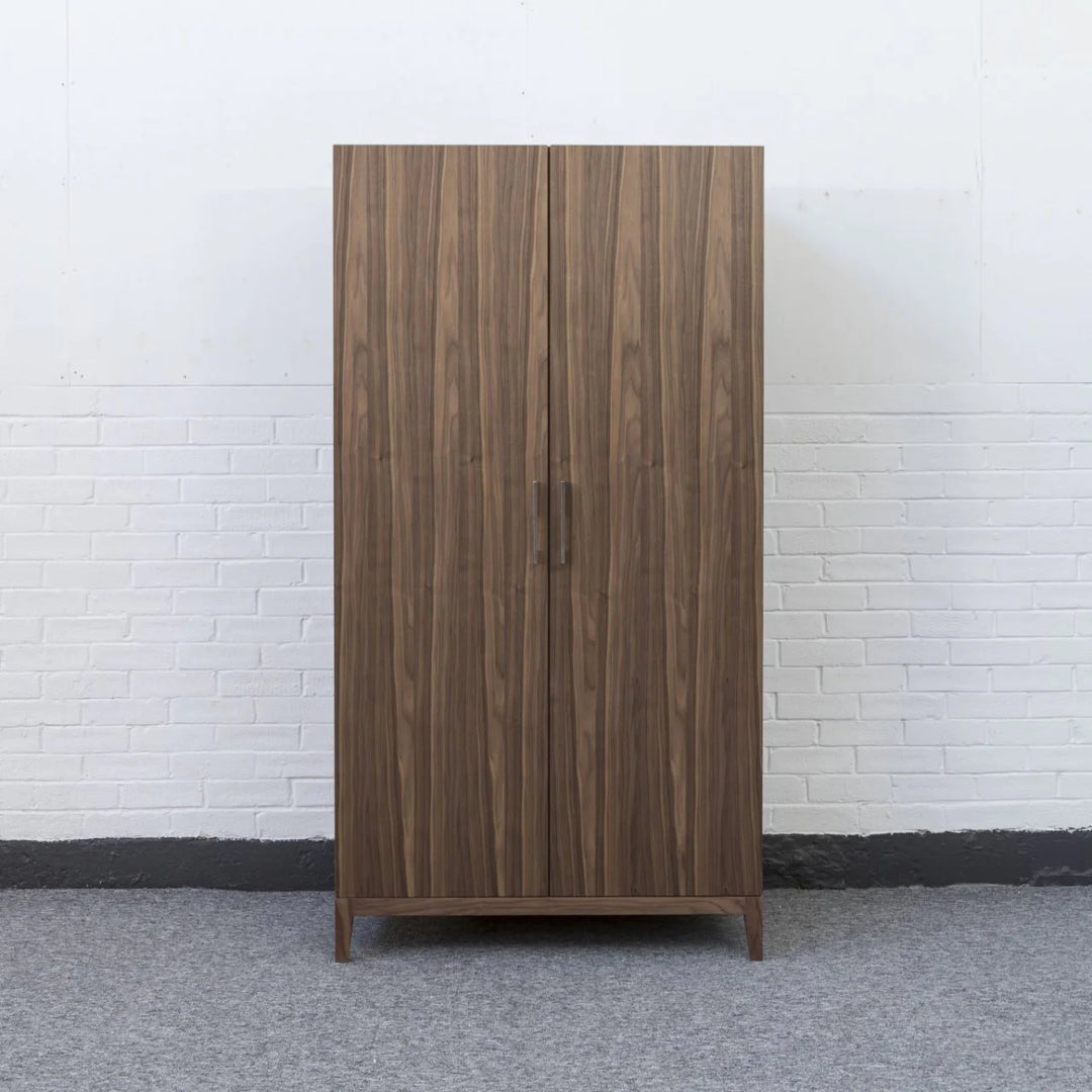 Wooden wardrobe against a white brick wall