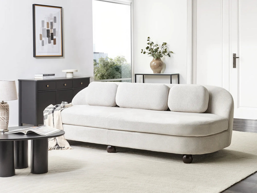 White sofa in a modern living room with a side table and lamp.