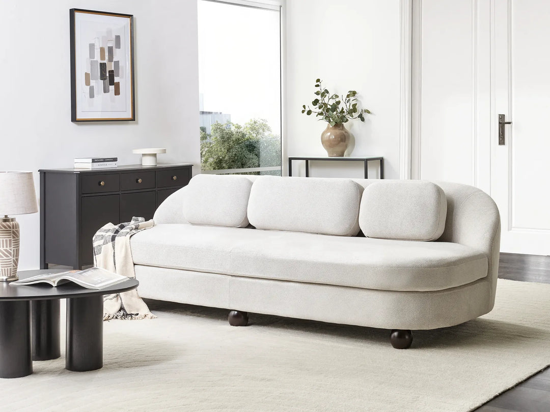 White sofa in a modern living room with a side table and lamp.