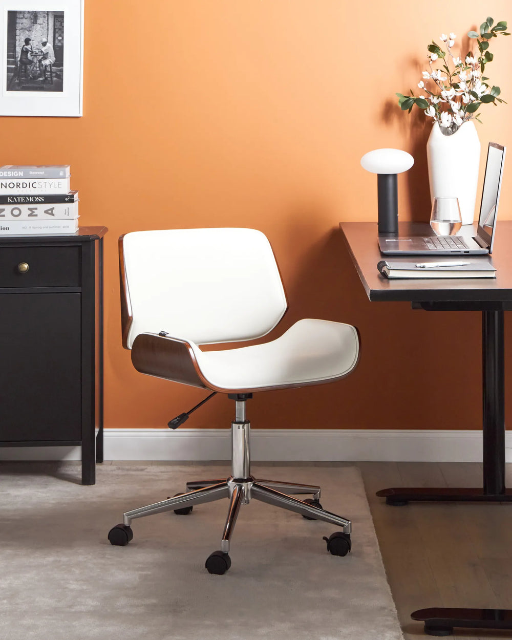 White office chair in a home office setting with an orange wall.