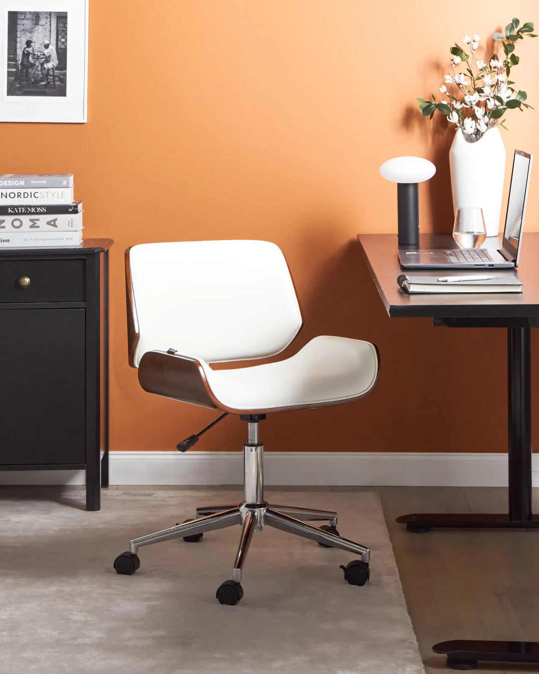 White office chair in a home office setting with an orange wall.