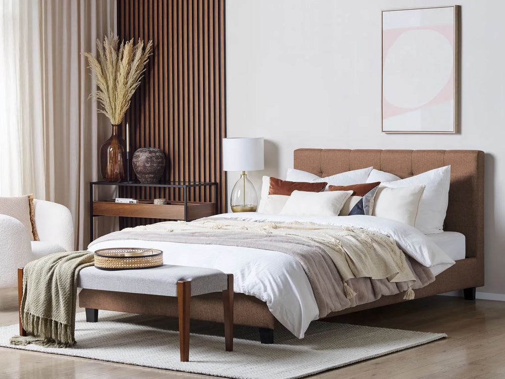 Modern bedroom with a brown bed, white bedding, and decorative items.