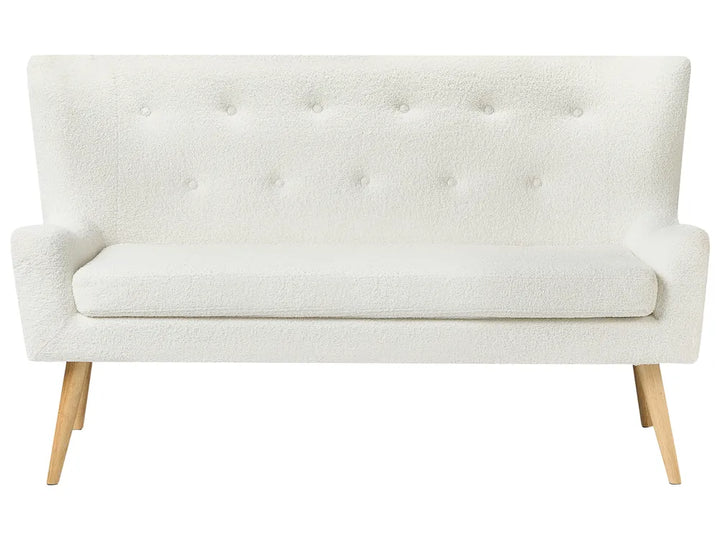 White tufted sofa with wooden legs on a white background