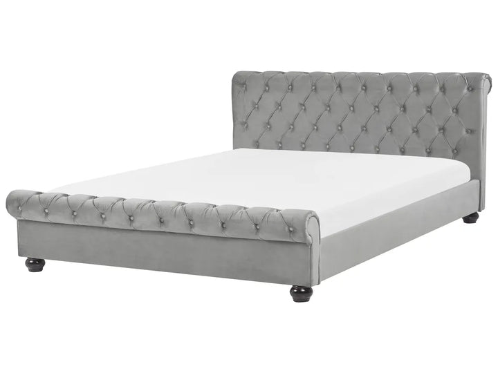 Gray tufted bed with white mattress on a white background