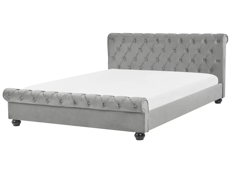 Gray tufted bed with white mattress on a white background