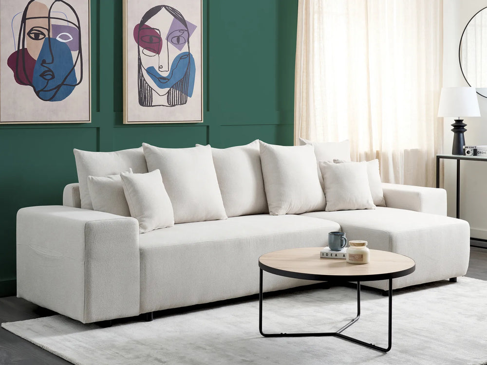 White sofa in a living room with abstract art on the wall and a coffee table.