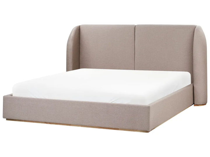Beige upholstered bed with white mattress on a white background