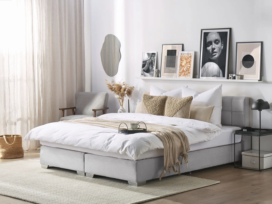 Modern bedroom with a gray bed, white bedding, and decorative pillows.