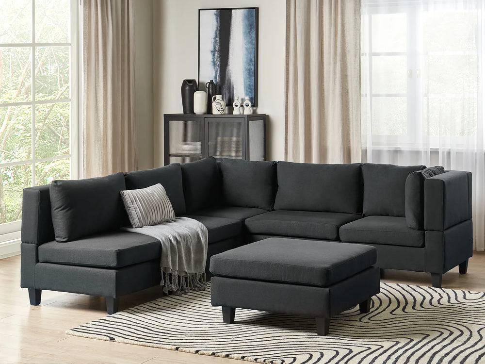 Gray sectional sofa in a living room with a rug and decorative items.