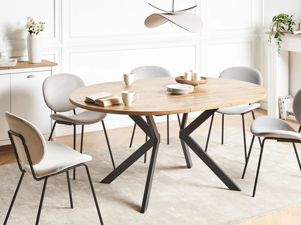 Dining room with a round wooden table and modern chairs.