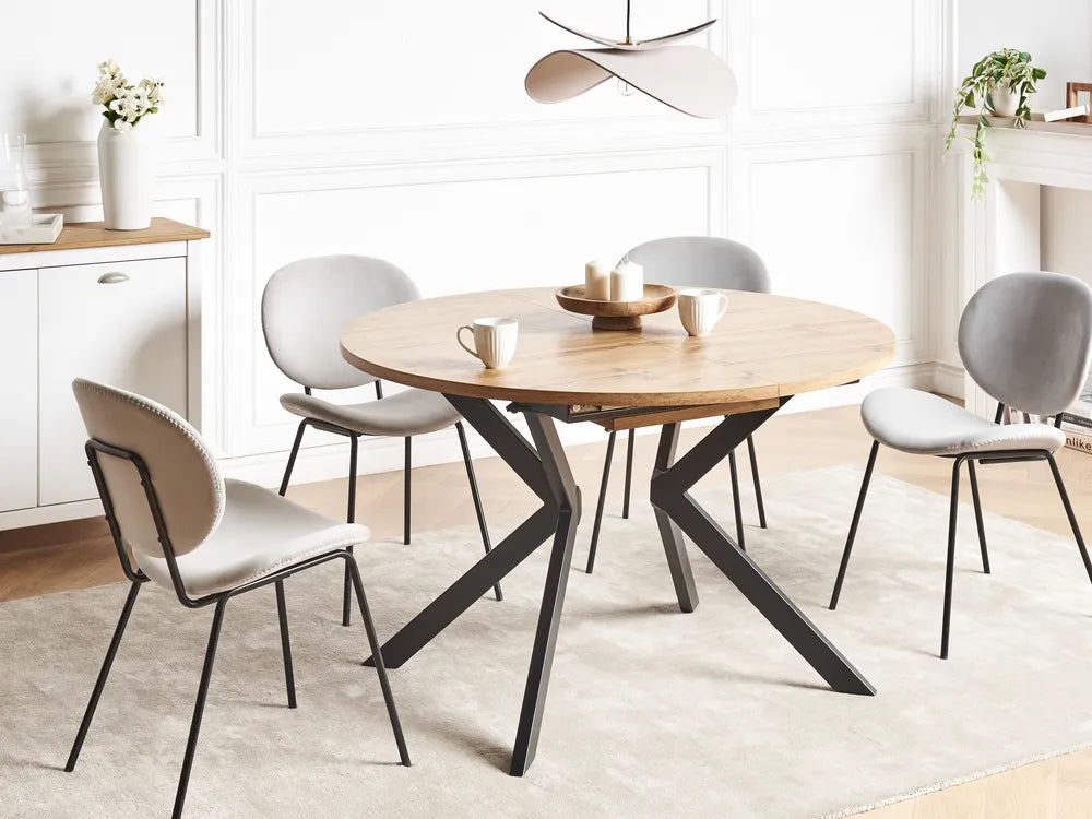 Dining room with a round wooden table and four chairs in a modern interior setting.
