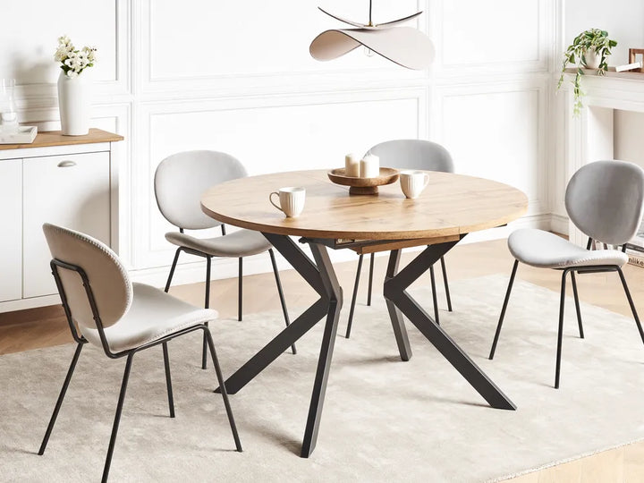 Dining room with a round wooden table and four chairs in a modern interior setting.