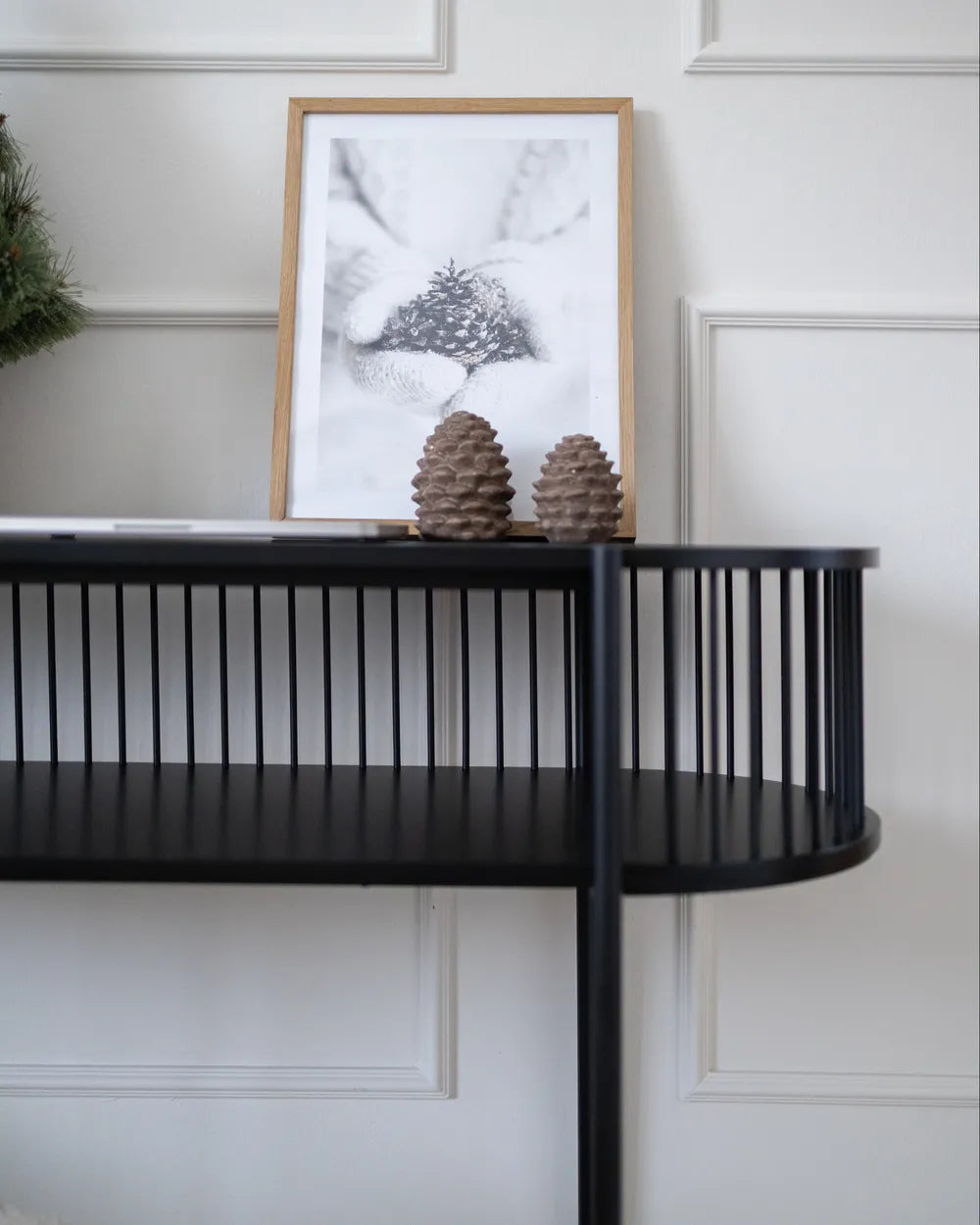 Black console table with decorative items against a white wall