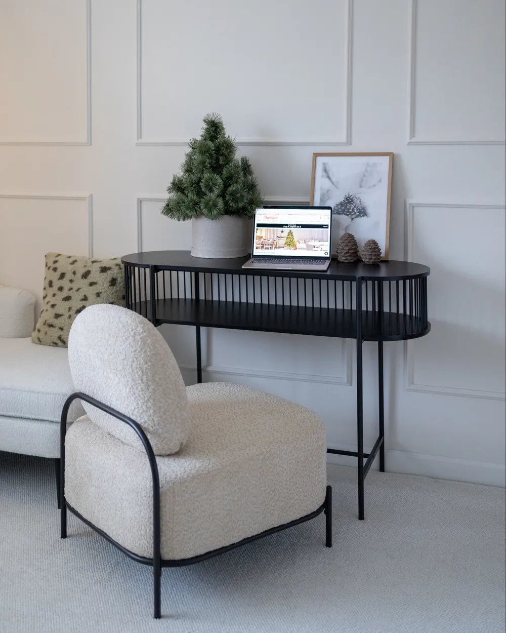 Modern living room with a white armchair, black console table, and decorative items.