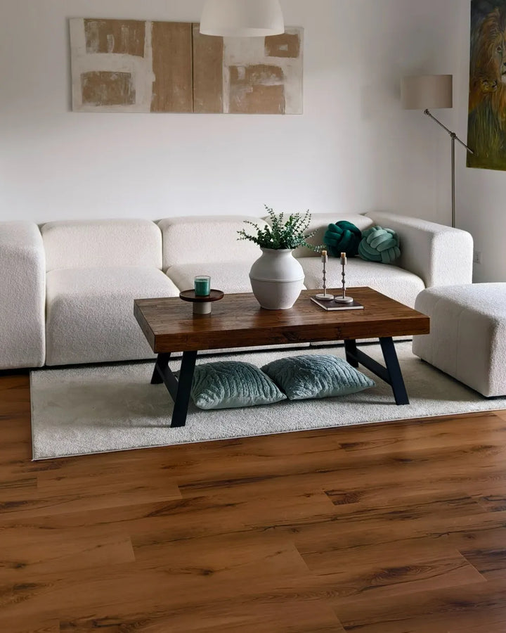 Modern living room with a white sofa, wooden coffee table, and decorative items.