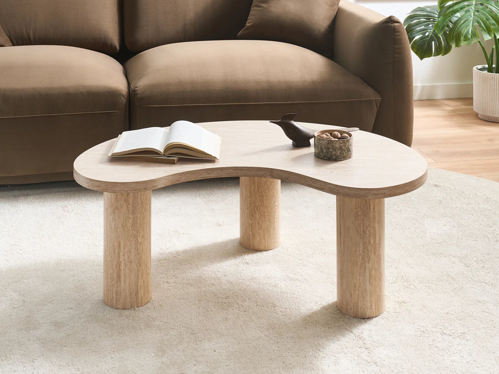 Wooden coffee table with a book and decorative items in a living room setting.