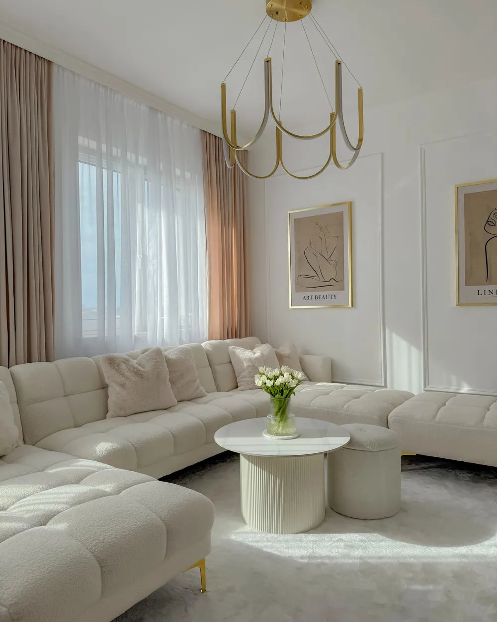 Modern living room with a beige sectional sofa, round coffee table, and decorative elements.