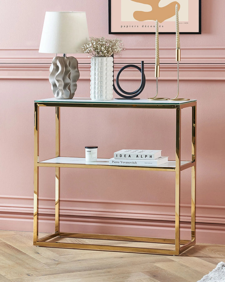 Gold side table with decorative items against a pink wall