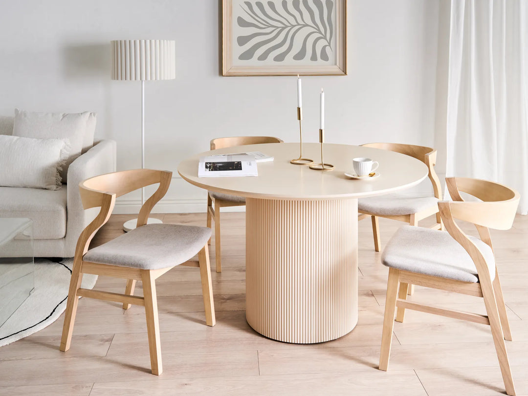 Dining area with a round wooden table and chairs in a modern living room.