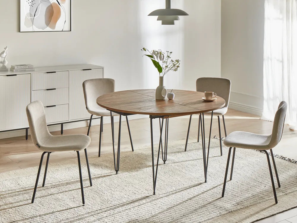 Dining room with a wooden table and chairs on a light wood floor.