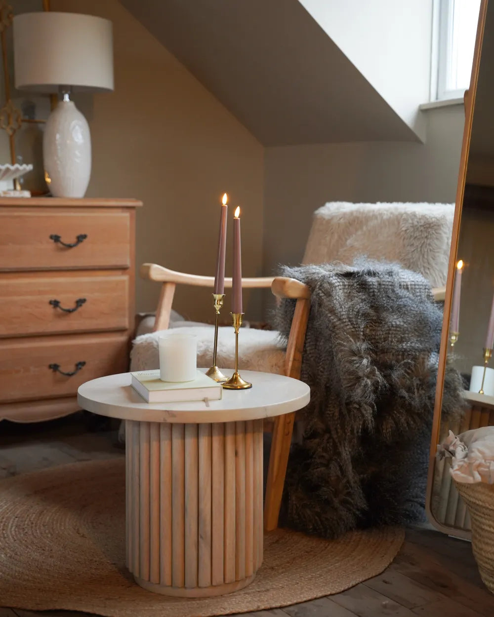 Cozy living room with wooden table, candles, and armchair.