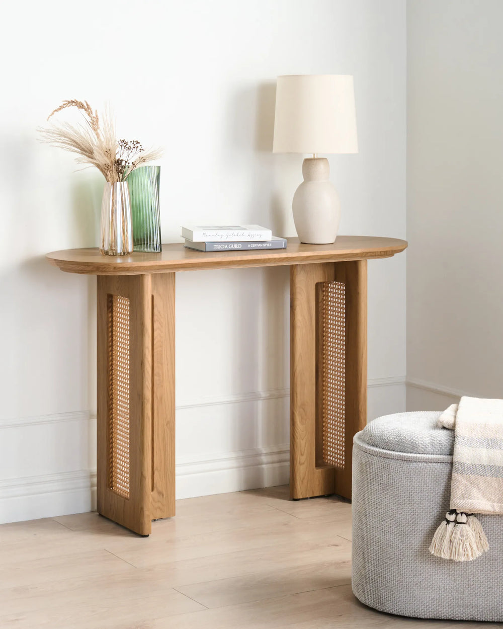 Wooden console table with decorative items against a white wall