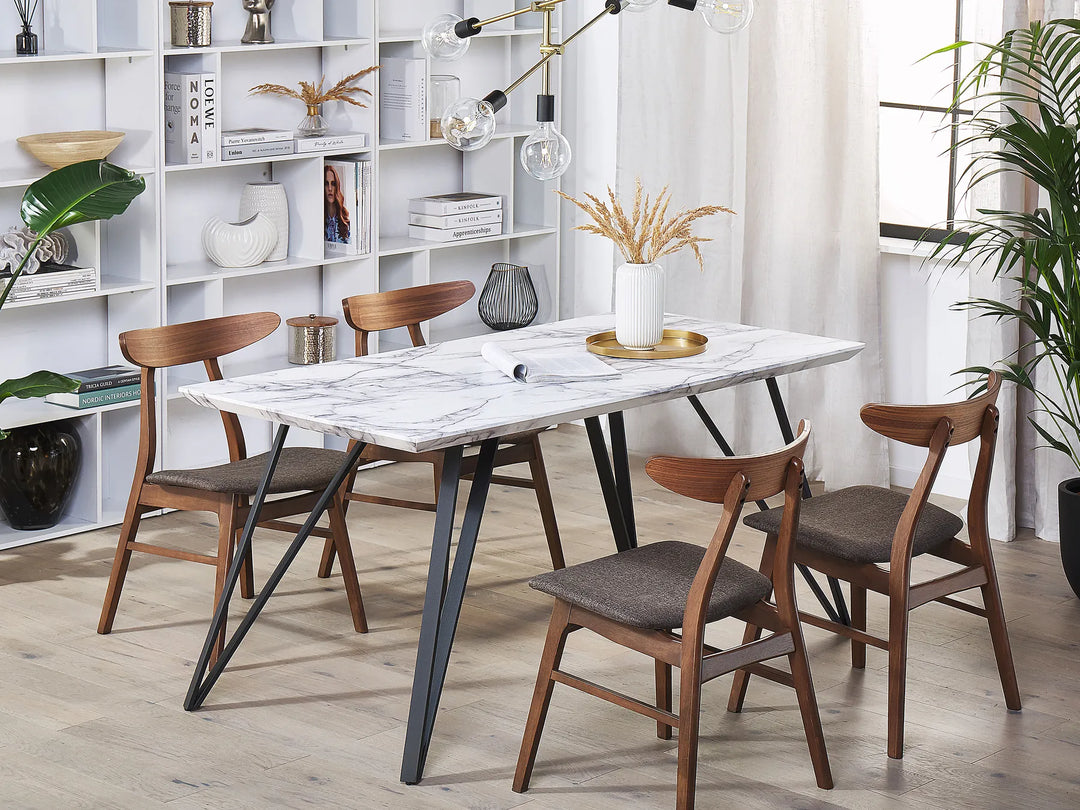 Dining room with marble table and wooden chairs in a well-lit room.