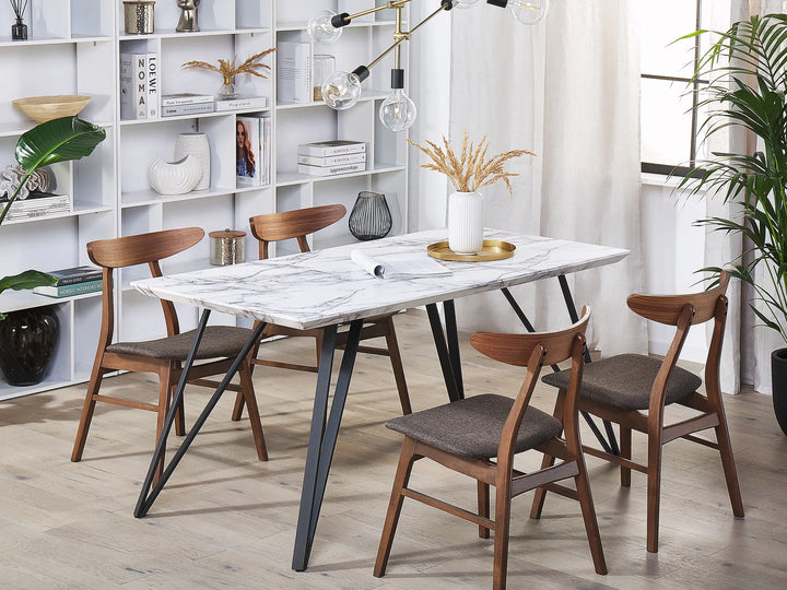 Dining room with marble table and wooden chairs in a well-lit room.