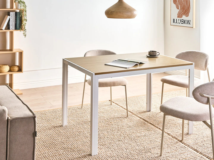 Dining area with a table, chairs, and a couch in a well-lit room.