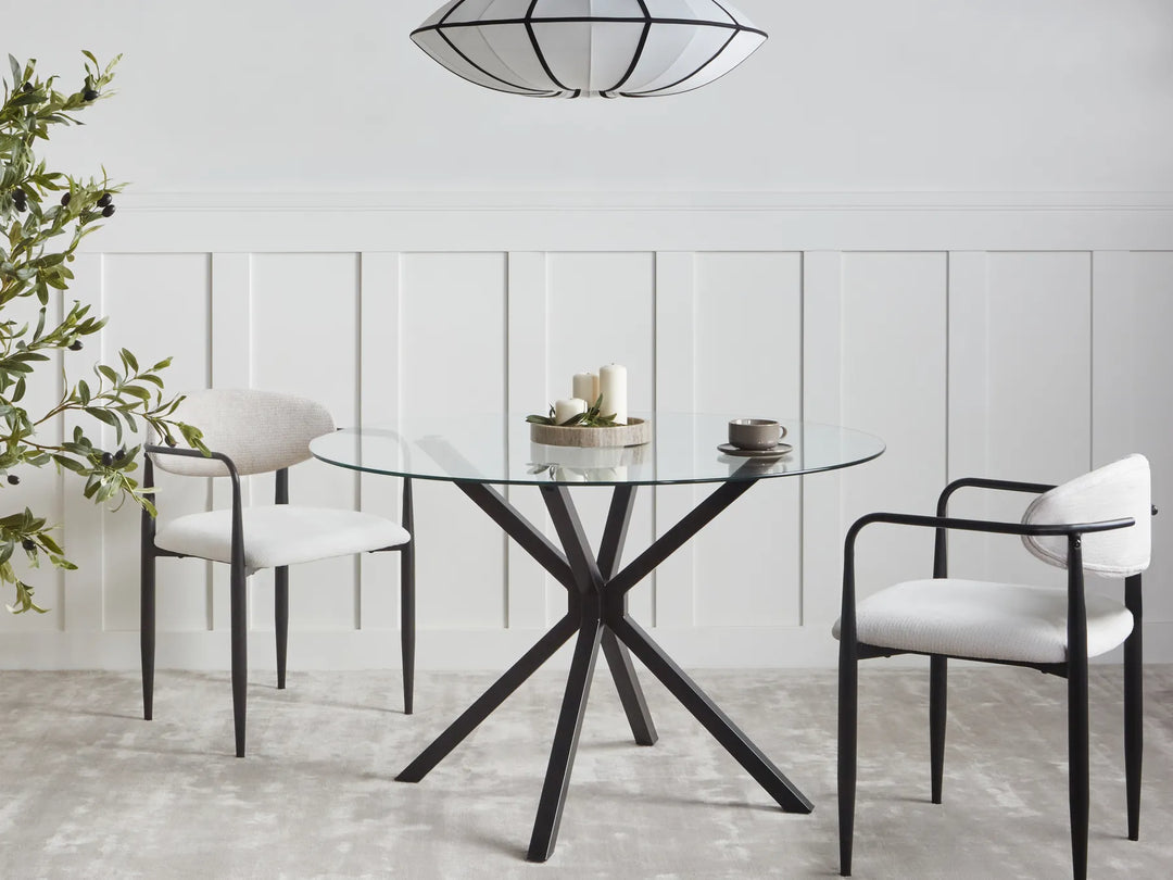 Modern dining room with a glass table and white chairs.