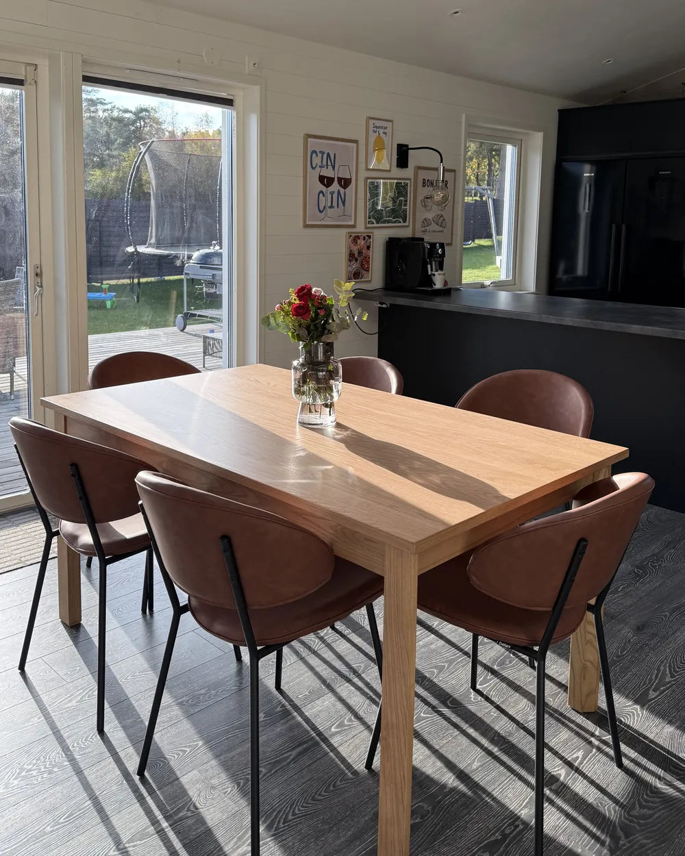 Dining area with wooden table and chairs in a modern kitchen.