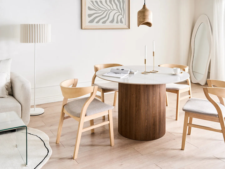 Dining area with a round wooden table and chairs in a modern living room.